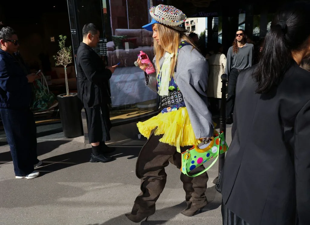 Image may contain Clothing Costume Person Child Adult Coat Accessories Bag Handbag Hat Skirt Footwear and Shoe