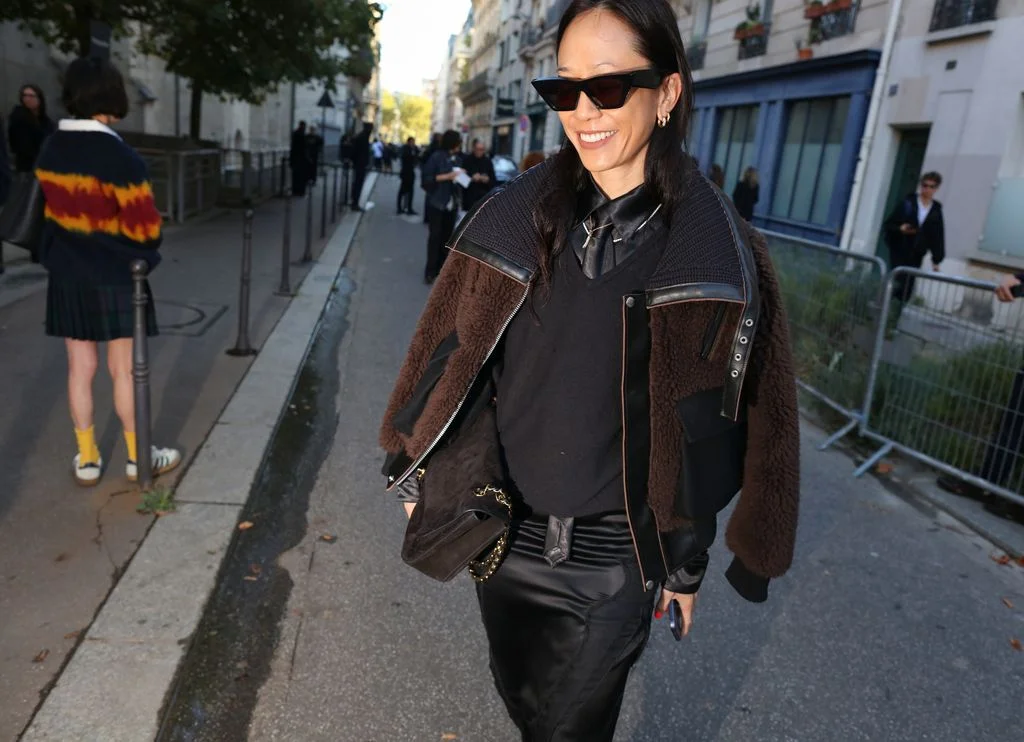 Image may contain Clothing Coat Jacket Person Adult Accessories Bag Handbag Vest Pants Sleeve Face and Happy