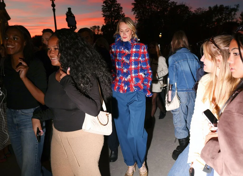 Image may contain Clothing Pants Accessories Bag Handbag Blouse Adult Person Jeans Footwear Shoe and Photobombing