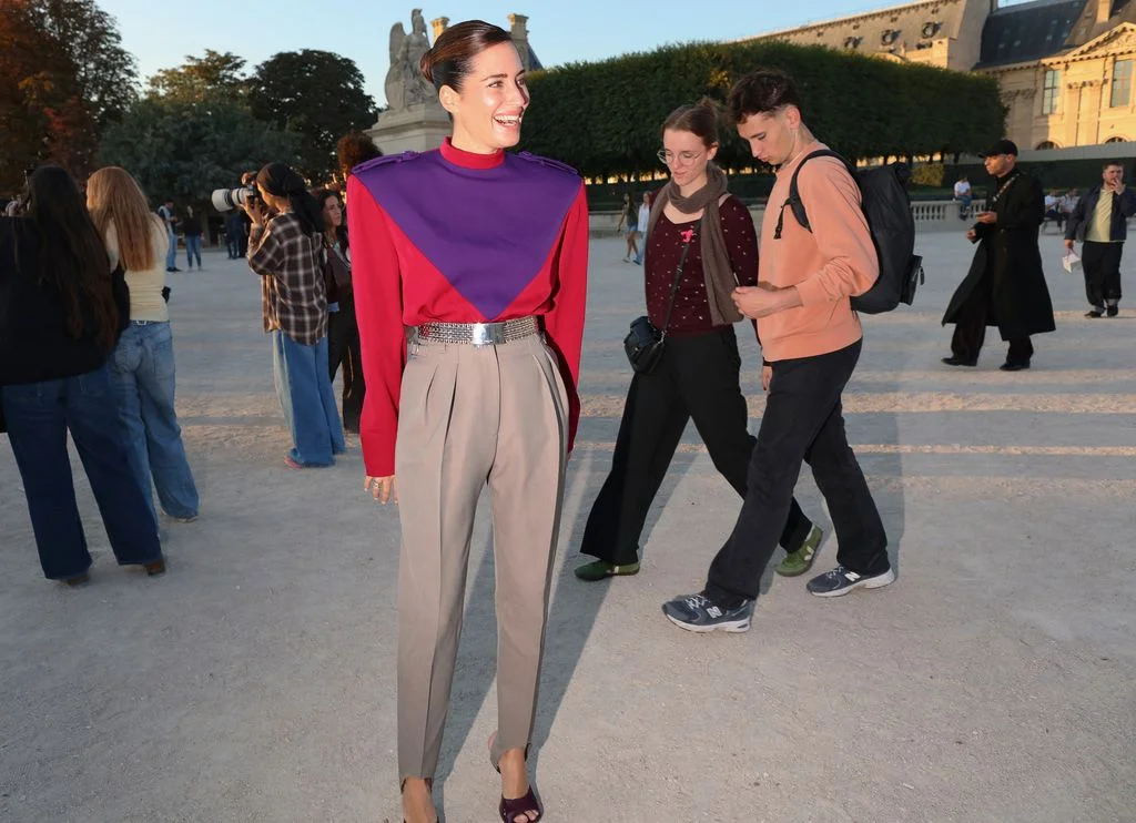 Image may contain Lucie Vchov People Person Walking Clothing Long Sleeve Sleeve Pants Cape Purple and Footwear
