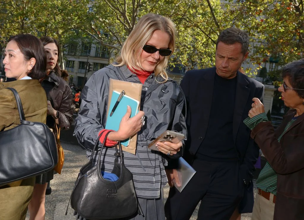 Image may contain Clothing Coat Accessories Bag Handbag Jacket Adult Person Purse Blazer Sunglasses and Light