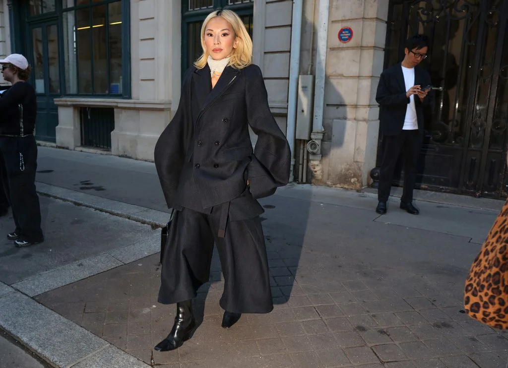 Image may contain Clothing Coat Person Adult Overcoat Formal Wear Suit Footwear and Shoe