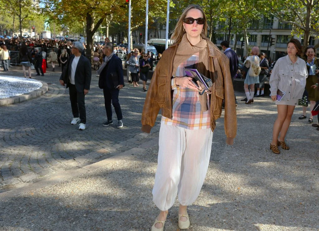 Image may contain Clothing Coat Jacket Pants Accessories Bag Handbag Adult Person Walking and Pedestrian