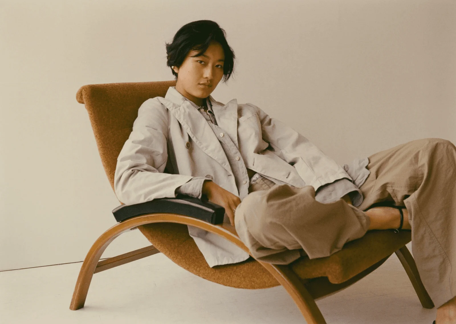 Image may contain Person Sitting Clothing Coat Furniture and Chair
