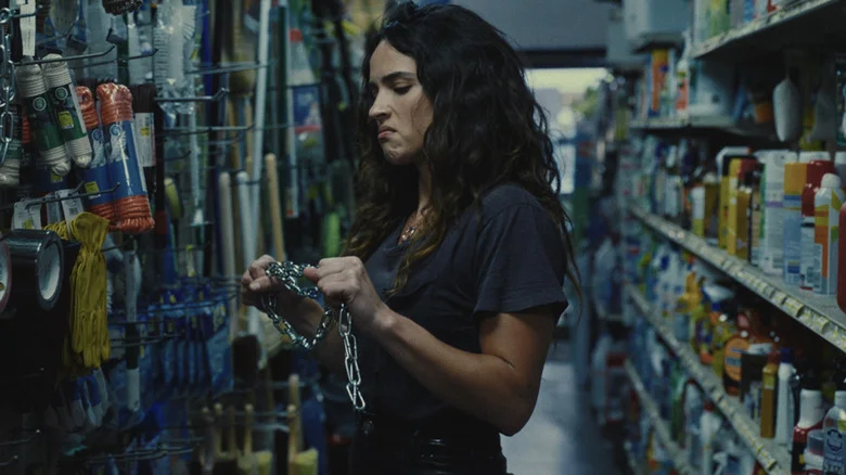 Adria Arjona's Celeste Cross holds a chain in a hardware store in Onslaught