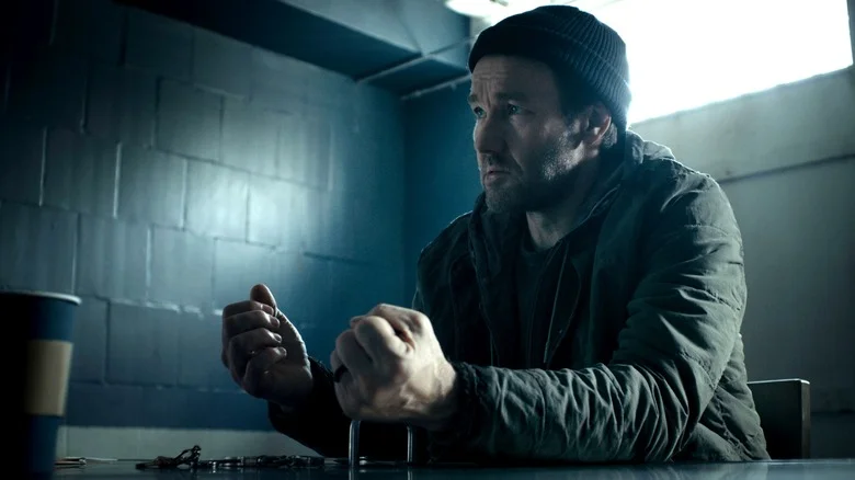 Joel Edgerton as Jason Dessen sitting in an interrogation room with his hands handcuffed to the table in Dark Matter